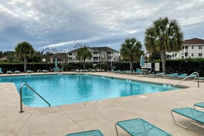 A swimming pool with lounge chairs and palm trees. - Chillville Unit 1635 (North Myrtle Beach)