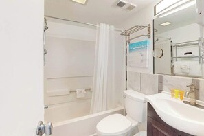 Une salle de bain moderne équipée d’une baignoire, de toilettes et d’un lavabo.