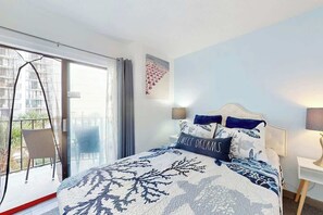 Une chambre à coucher avec un lit, une table de chevet, une chaise et une vue sur l’extérieur.