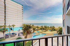 A hotel balcony with a view of a beach and a pool area. - Cozy Beach Rendezvous at The Palace Resort (Myrtle Beach)