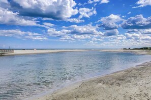 A beach with a pier extending into calm waters, a sandy shore, and a partly cloudy sky. - Ocean Creek Plantation EE6 (Myrtle Beach)