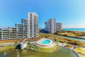 A high-rise residential building with a pool and landscaped areas. - Ocean Creek Plantation EE6 (Myrtle Beach)
