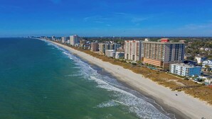 A coastal cityscape with a long beachfront, high-rise buildings, and a clear sky. - Hermosa Villa Retreat (North Myrtle Beach)