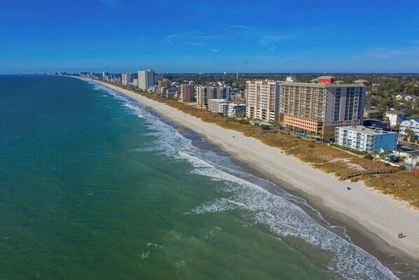A coastal cityscape with a long beachfront, high-rise buildings, and a clear sky. - Hermosa Villa Retreat (North Myrtle Beach)