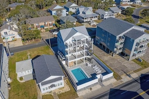 A residential area with multiple houses, a swimming pool, and a large building with a balcony. - Hermosa Villa Retreat (North Myrtle Beach)