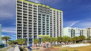 Et hotel med flere etager, altaner, et poolområde og en rutsjebane.