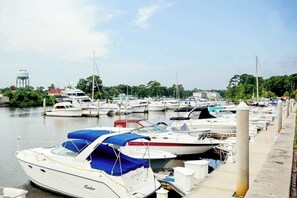 Un port de plaisance où sont amarrés de nombreux bateaux, une tour à eau et un quai équipé de bornes d’amarrage.