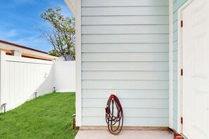 A white garage door, a white fence, and a green lawn. - Gulfstream Cottages 402 (Myrtle Beach)