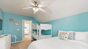 A bedroom with a bunk bed, a ceiling fan, and a bed with a beach-themed pillow. - Gulfstream Cottages 402 (Myrtle Beach)