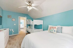 A bedroom with a bunk bed, a ceiling fan, and a bed with a beach-themed pillow. - Gulfstream Cottages 402 (Myrtle Beach)