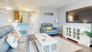 A modern living room with a sofa, a coffee table, and a cabinet. - Gulfstream Cottages 402 (Myrtle Beach)