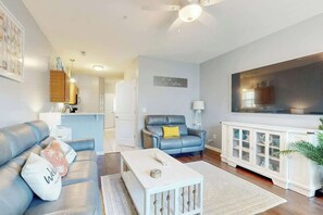 A modern living room with a sofa, a coffee table, and a cabinet. - Gulfstream Cottages 402 (Myrtle Beach)