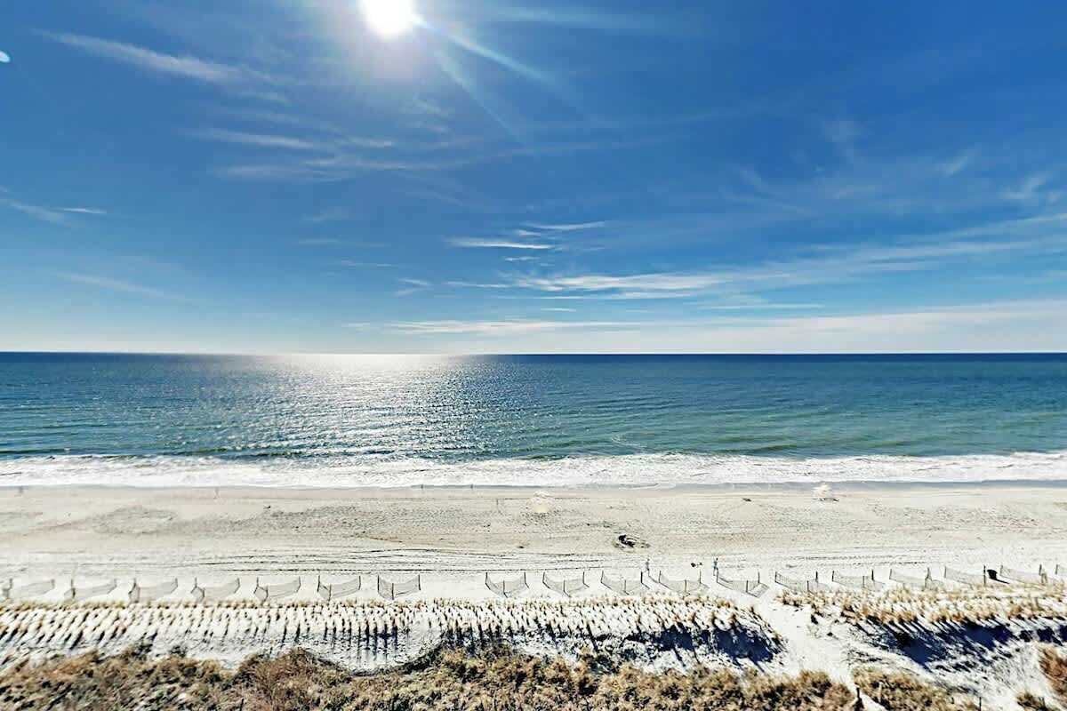 A beach with a clear sky and calm sea.