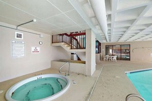 An indoor swimming pool with a 3 ft depth marker, a no glass containers sign, a caution sign, and a staircase with a red railing. - Sea Winds Unit 608 Condo (North Myrtle Beach)