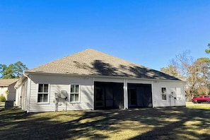 Einbungalow mit Garage, überdachter Veranda und Rasenfläche.