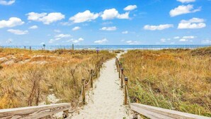 A sandy path leading to a beach with a clear sky. - Myrtle Shores Retreat (Myrtle Beach)