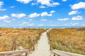 A sandy path leading to a beach with a clear sky. - Myrtle Shores Retreat (Myrtle Beach)