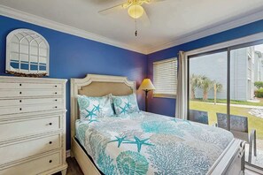 A bedroom with a bed, dresser, and a view of the outdoors. - Myrtle Shores Retreat (Myrtle Beach)