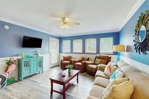 A living room with a ceiling fan, a television, a sofa, and a coffee table. - Myrtle Shores Retreat (Myrtle Beach)