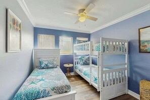 A bedroom with a bunk bed, a ceiling fan, and a small round table. - Myrtle Shores Retreat (Myrtle Beach)