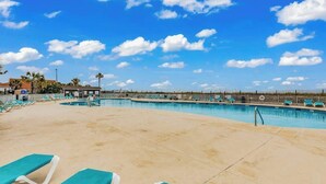 A pool area with lounge chairs and a clear sky. - Myrtle Shores Retreat (Myrtle Beach)