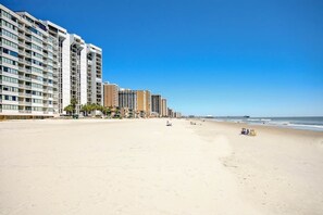 A beachfront hotel with multiple floors, a sandy beach, and a clear blue sky. - Sands Beach Club 524 The Chill Pill (Myrtle Beach)
