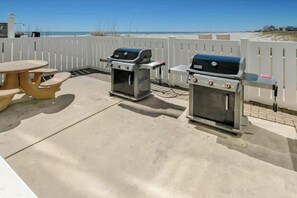 An outdoor patio with two barbecue grills and a picnic table. - Sands Beach Club 524 The Chill Pill (Myrtle Beach)