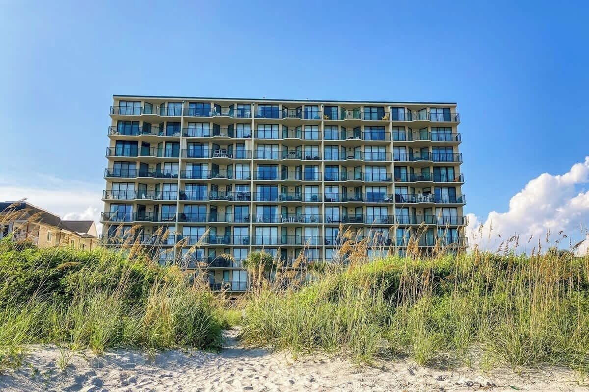 A multi-story hotel with a modern design, featuring balconies on each floor.