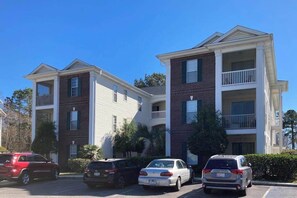 A multi-story residential building with a parking lot. - Golfside Escape | River Oaks Sixty-One M (Myrtle Beach)