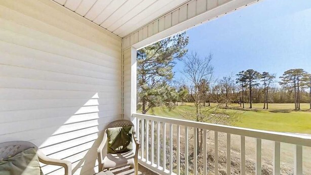 A covered porch with a view of a golf course. - River Oaks Unit 61M Condo (Myrtle Beach)