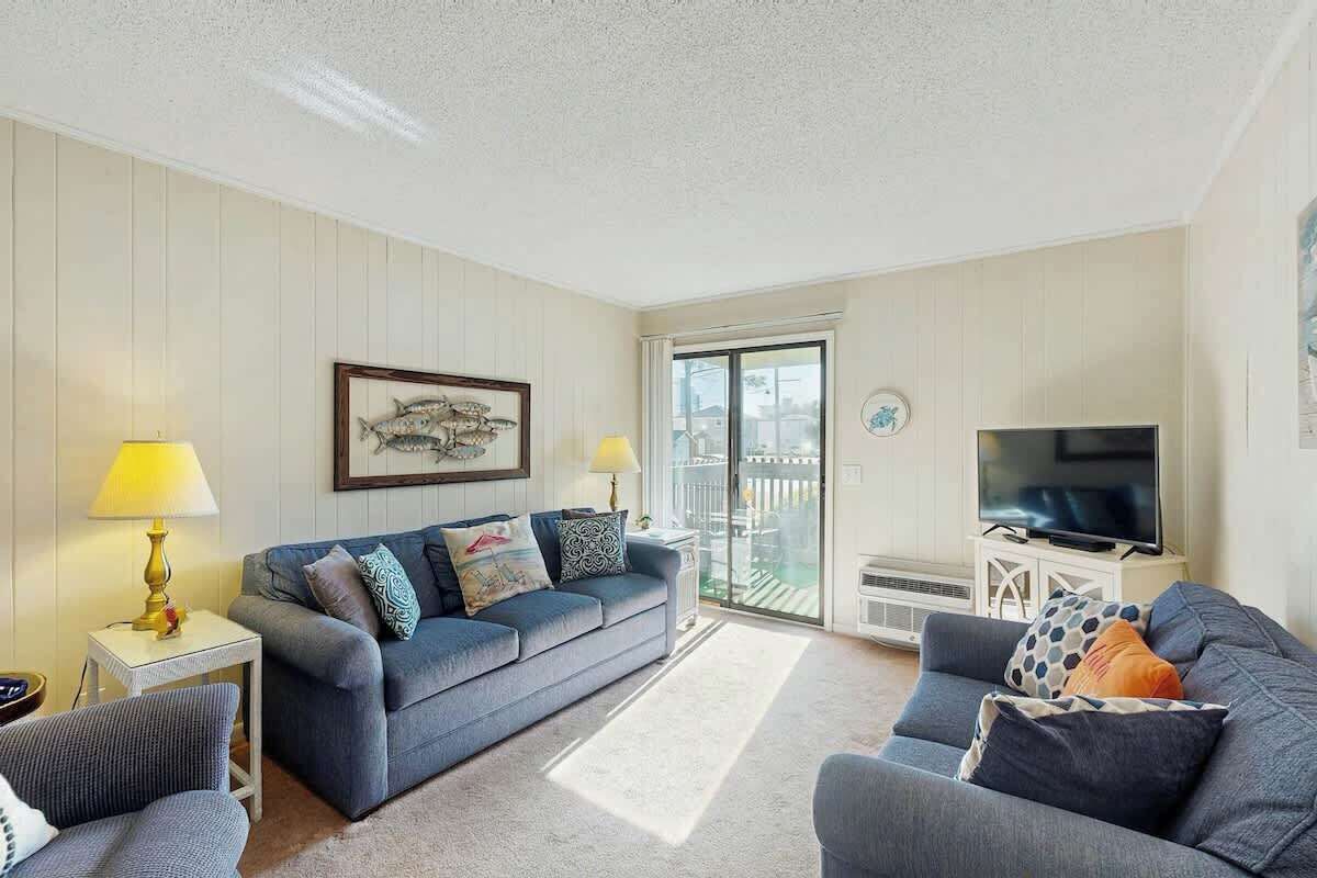 A living room with a sofa, a television, and a balcony door.