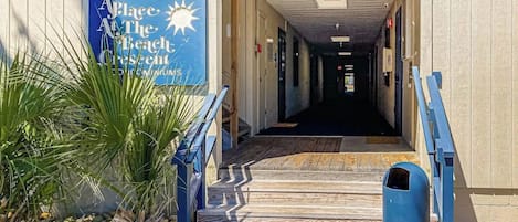 L’entrée d’un immeuble, avec une enseigne indiquant « Place at the Beach » et le numéro « 405 » au-dessus.