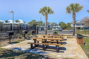 A parking lot with picnic tables and a trash bin. - Beach Happy Place Retreat (North Myrtle Beach)