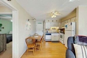 Un espace de vie compact comprenant un coin repas, une kitchenette et un canapé.