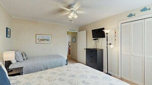 A bedroom with a bed, a desk, a dresser, a ceiling fan, and a wardrobe. - Beach Happy Place Retreat (North Myrtle Beach)
