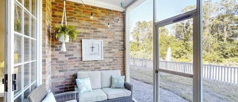A room with a brick wall, a sofa, and a large window.