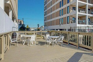 A balcony with outdoor furniture and a view of a multi-story building. - Sea Marsh II Unit 1002 (North Myrtle Beach)