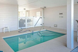 Ein Schwimmbecken mit weißem Zaun, einer Poolleiter und einem Schild mit der Aufschrift 'KEIN TAUCHEN'.