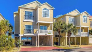 A multi-story residential building with balconies, a covered entrance, and a clear sky. - Pointe Marsh Unit 2414 (North Myrtle Beach)