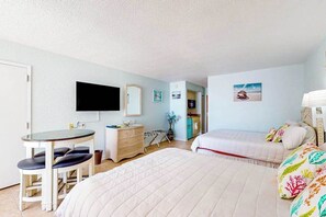 Ein Zimmer mit einem Bett, einem Schreibtisch mit Stuhl, einem Fernseher und einer Tür.