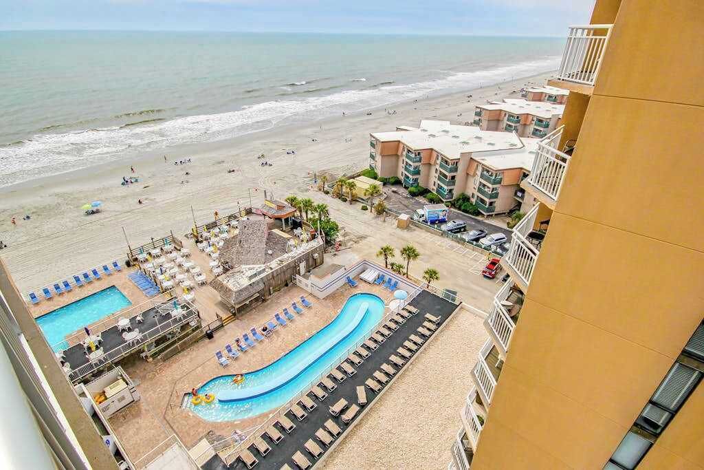 A resort with a swimming pool, beach access, and a view of the ocean.