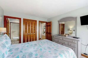 A bedroom with a bed, a dresser, a television, and a mirror. - Shipwatch Pointe I E-308 (Myrtle Beach)