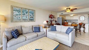 A living room with two sofas, a coffee table, and a dining area with chairs and a table. - Water's Edge Resort 1501 (Murrells Inlet)