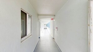 A corridor with a door marked 'EXIT' and a window on the left. - Water's Edge Resort 1501 (Murrells Inlet)