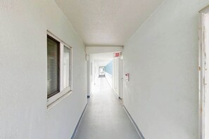 Ein Korridor mit einer Tür, die mit 'EXIT' beschriftet ist, und einem Fenster links.
