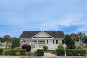 A single-story house with a front porch, a fenced yard, and a sign indicating it's for sale. - Turtle Cove Beach Retreat (Myrtle Beach)