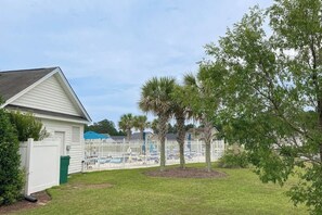 A residential area with a white house, a fenced pool area, and a tree. - Turtle Cove Beach Retreat (Myrtle Beach)