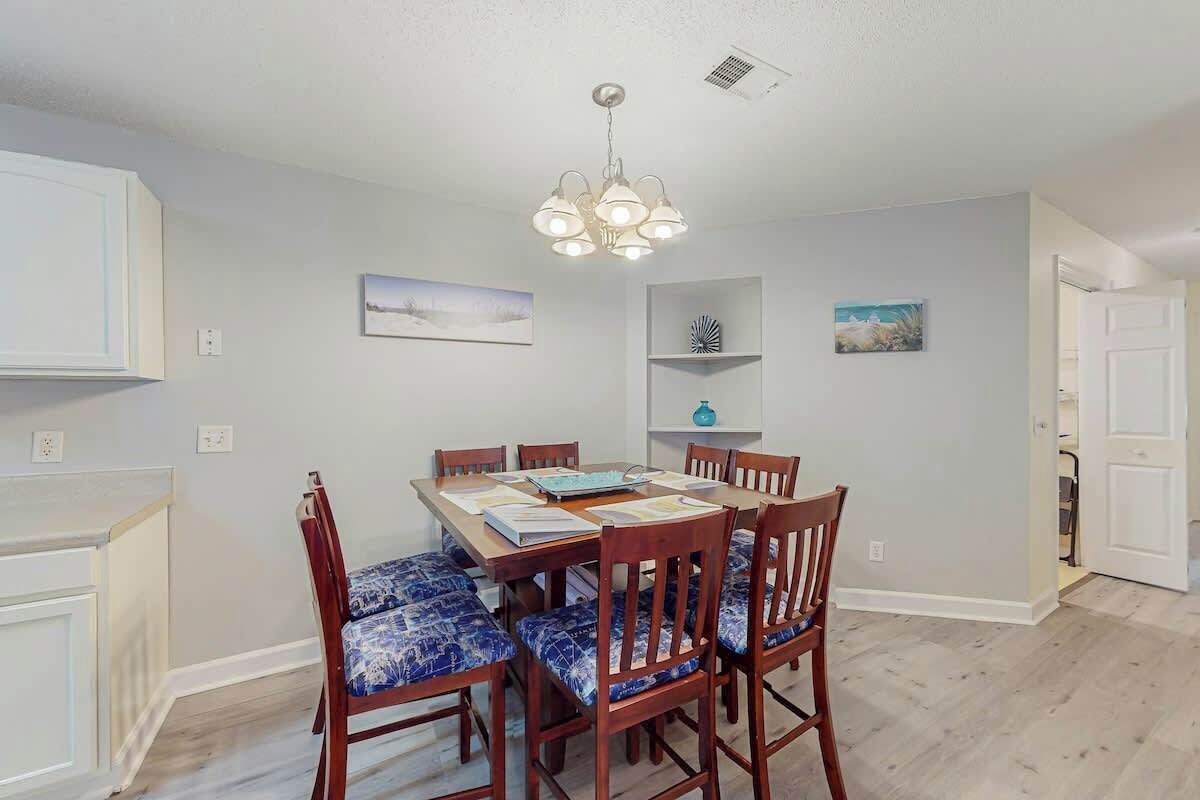 A dining area with a table, chairs, and a chandelier.