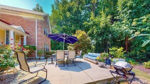 An outdoor patio with a grill, seating, and a covered table. - Seascape Beach Retreat (Murrells Inlet)