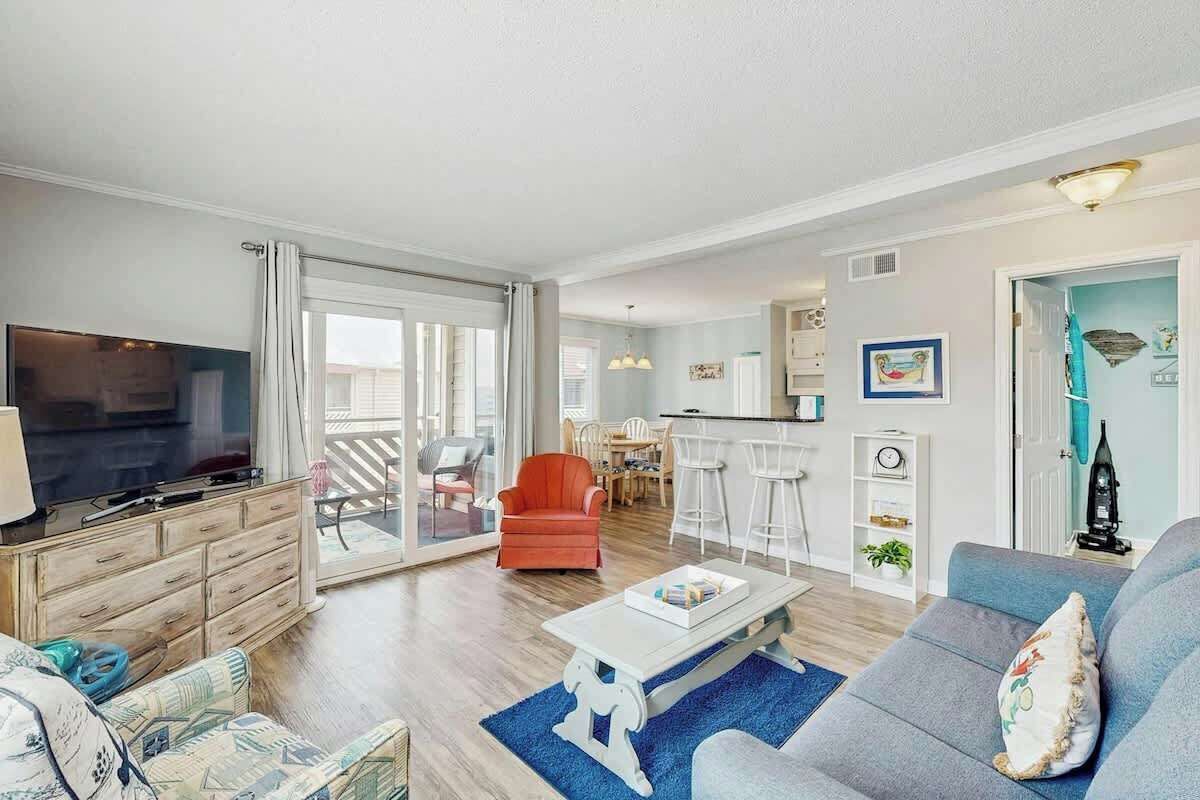 A spacious living room with a television, sofa, and chairs.